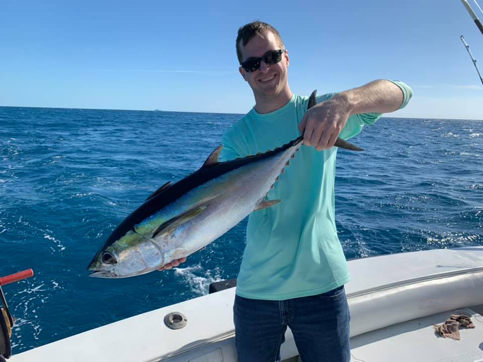 Joshua Harris, Founder of Agency Growth Secrets, holding a fish while standing on a boat.